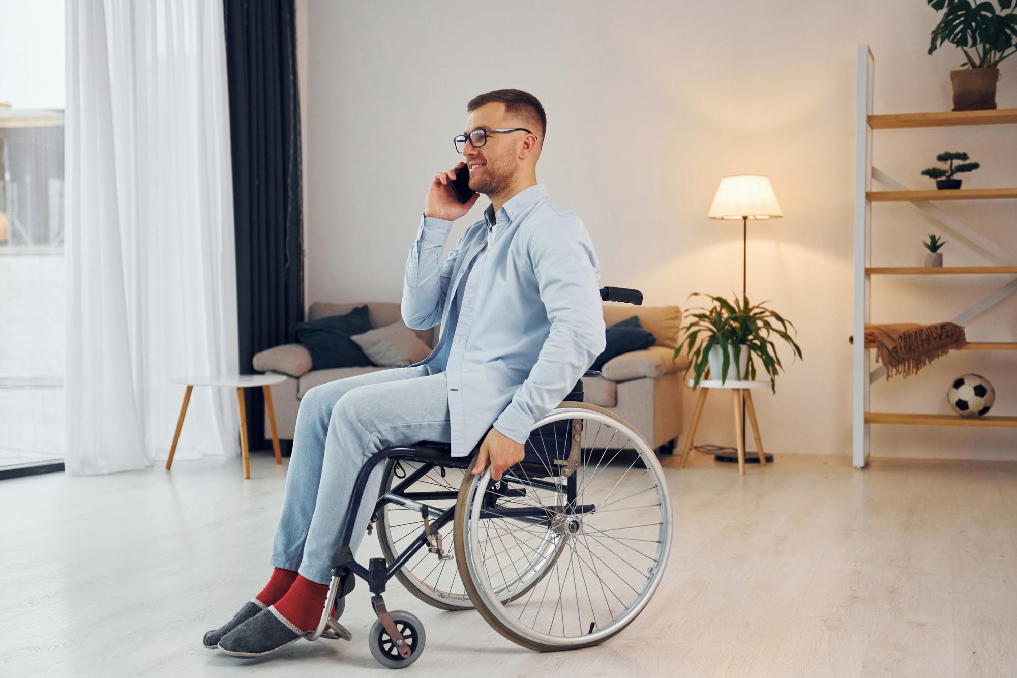 Professional man in wheelchair making phone call about home caring Melbourne services with CareAU - getting started guide