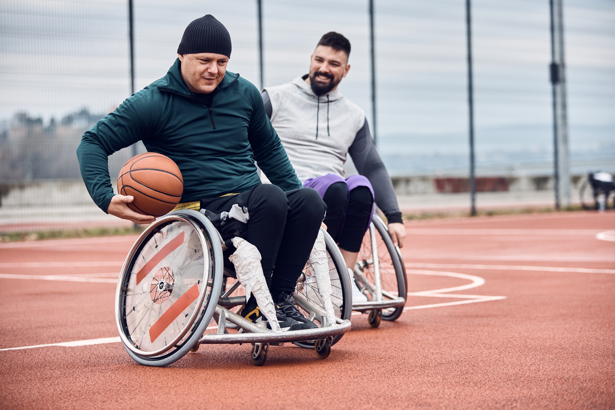 Two men in wheelchairs playing basketball – life skills development for independence and confidence