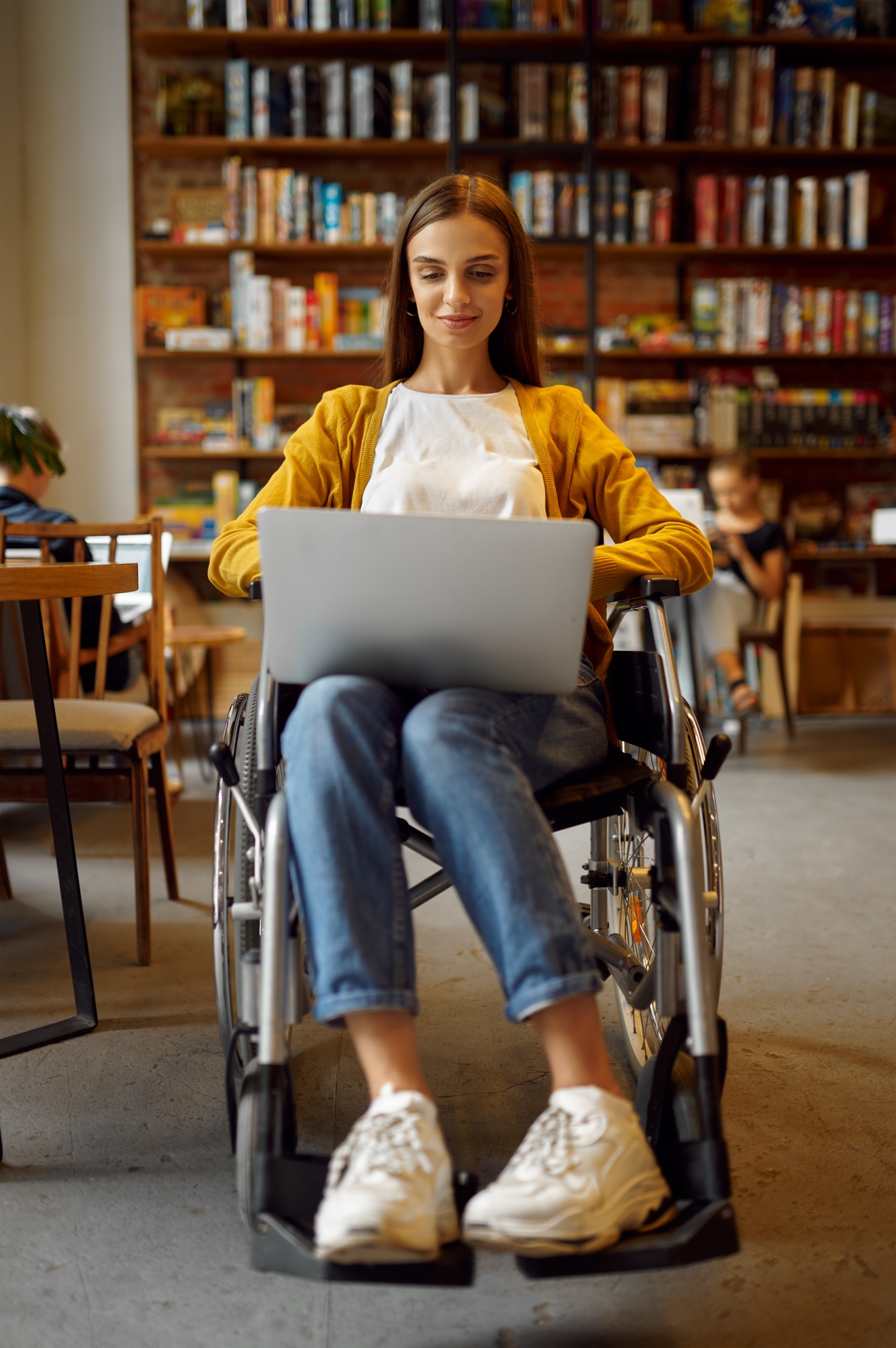 Disabled student in wheelchair works on laptop